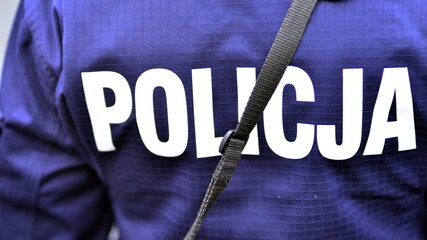 Police sign - logo on the back of the police uniform. Policja.