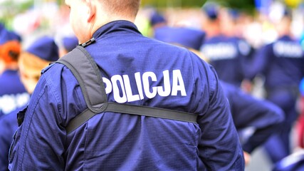 Police sign - logo on the back of the police uniform. Policja. © Grand Warszawski
