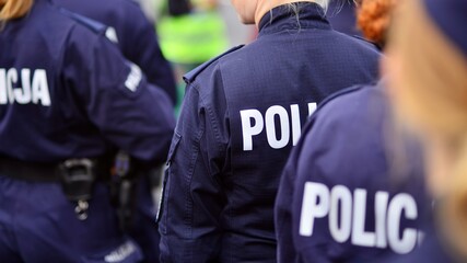 Police sign - logo on the back of the police uniform. Policja. © Grand Warszawski