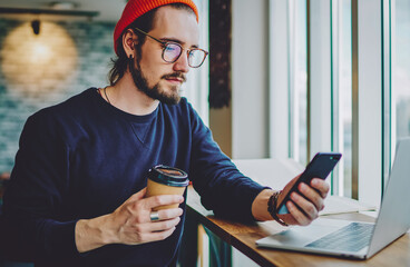 caucasian hipster guy reading news on coffee break