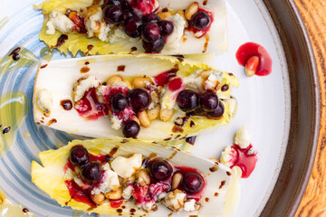Belgium endive boats with huckleberries, nuts and cheese