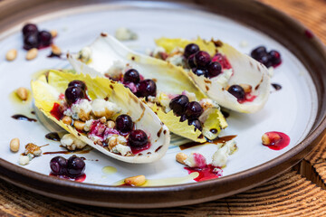 Belgium endive boats with huckleberries, nuts and cheese