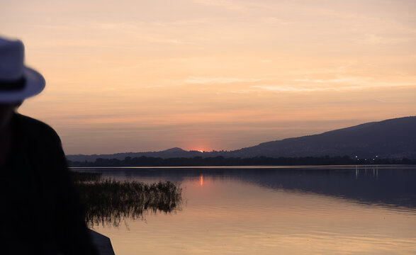 Silhouette of a person with panama hat looking at the sunset in Bosisio Parini at Lake Pusiano in Italy