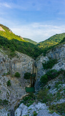 Fototapeta na wymiar Charming waterfall in a limenstone wall covered with vegetation