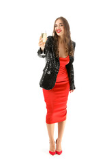 Young woman with glass of champagne on white background. New Year celebration