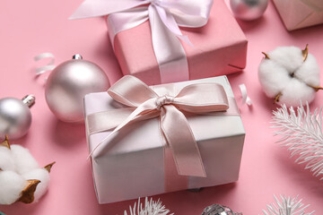 Composition with gifts and Christmas decor on pink background