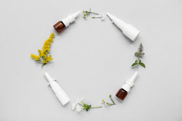 Frame made of nasal drops and different flowers on grey background