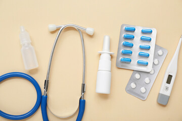 Medical supplies with nasal drops on beige background