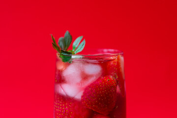 close-up of a glass with strawberry drink isolated on a red background