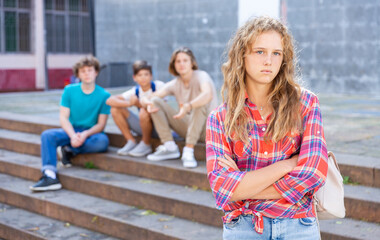 Portrait of offended girl after quarrel with friends outdoors