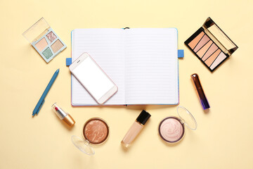 Composition with makeup cosmetics, modern mobile phone and notebook on beige background