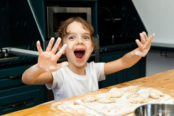 Mom's little helper. Cute little girl in flour sculpts dumplings. Girl makes dumplings for dinner....
