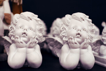 Plaster figurines of angels on a store counter, soft focus. Christmas decor. Preparation for the holiday