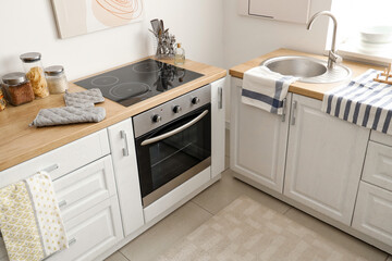 Interior of light kitchen with white counters and oven