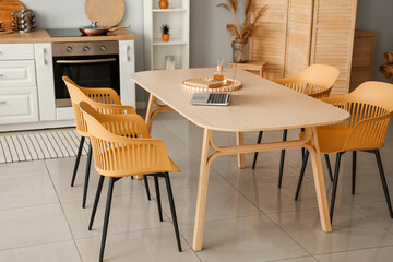 Interior of light kitchen with white counters and dining table