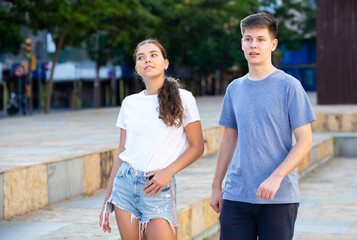 Two teenagers are talking about play on walk on the street