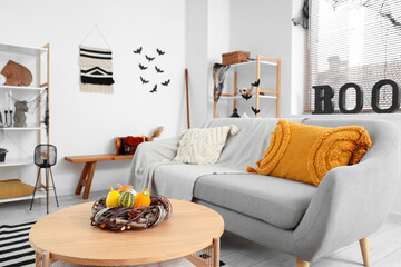 Interior of living room decorated for Halloween with grey sofa and table