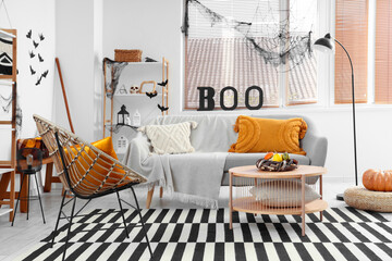 Interior of living room decorated for Halloween with grey sofa and armchair