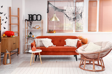 Interior of living room decorated for Halloween with red sofa and armchair