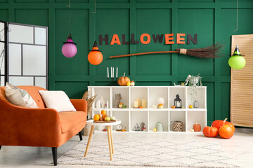 Interior of living room decorated for Halloween with red sofa and shelf unit