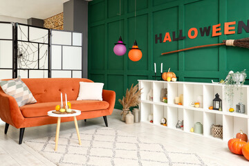Interior of living room decorated for Halloween with red sofa and shelf unit