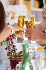 People who toast each other with beer glasses in their hands, cheers
