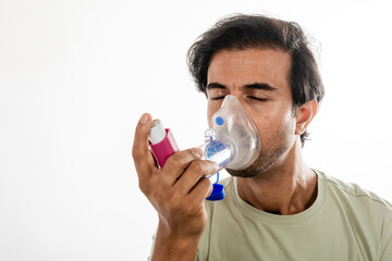 Young man using a respiratory inhaler.