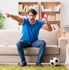 Man watching football at home sitting in couch