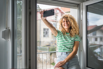 woman at the window use mobile phone take selfie photo self portrait
