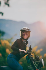 woman wearing safety helmet riding small enduro motorcycle against beautiful background