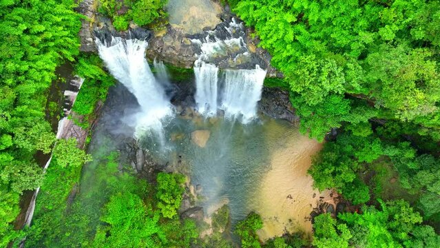 A mesmerizing waterfall nestled in a lush, emerald tropical forest, where nature's beauty dances in the glistening cascades, painting a canvas of love. Thailand. Bird's eye view. Nature concept.
