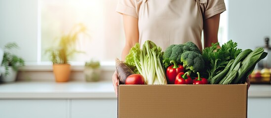 Online ordered vegetables being delivered and opened by a woman at home - obrazy, fototapety, plakaty