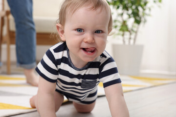 Cute baby crawling on floor at home