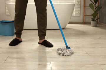 Man cleaning floor with mop indoors, closeup