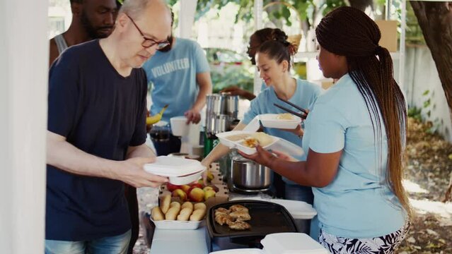 Non-profit group dedicates itself to hunger relief by giving free food to homeless people. Volunteers serving meals to individuals from various backgrounds, fostering a sense of community and support.