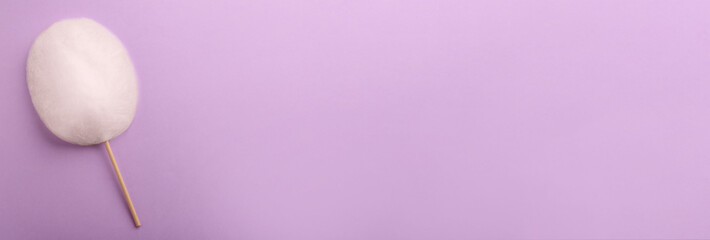 Sweet cotton candy on violet background, top view. Banner design with space for text