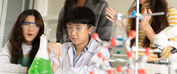 STEM education concept. Asian children in laboratory research an experiment exam with chemistry...