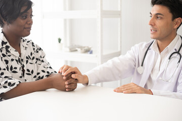 Hispanic physician check-up African American patient with stethoscope at the hospital. Healthcare medical diagnosis and examining.