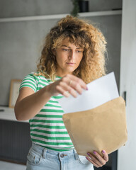 caucasian woman open mail letter or document envelope at home