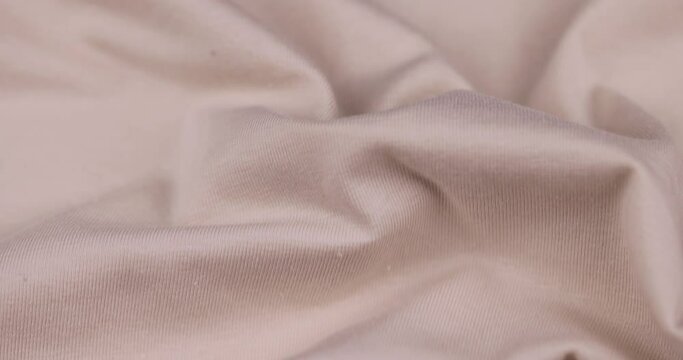 beige cotton fabric close-up, details of a piece of clothing sewn from soft beige cotton fabric