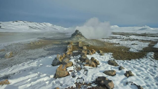 Snow covered path with hot steam from geiser. Iceland