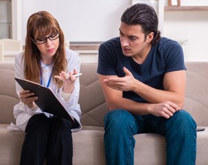 Young male patient discussing with female psychologist personal