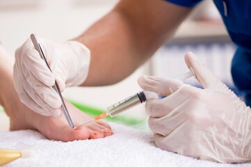 Podiatrist treating feet during procedure