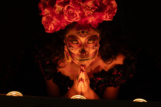 Calavera Catrina sitting on a throne. Sugar skull makeup. Dia de los muertos. Day of The Dead. Halloween.