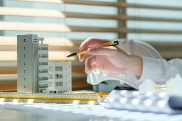 Architects constructing model of buildings and examining their project at office. Urban...