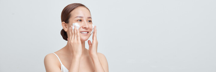 Banner of Smiling young woman washing foam face by natural foamy gel