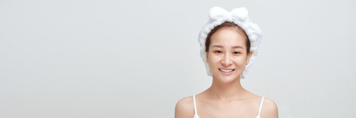 Happy confident young lady with towel on head touching moisturized soft healthy sensitive skin
