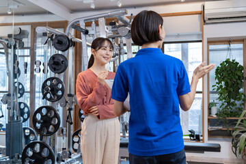 トレーナーから説明を受ける日本人