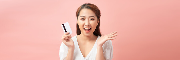 excited young asian woman holding credit card in hand, happy about sales and purchases, banner,...