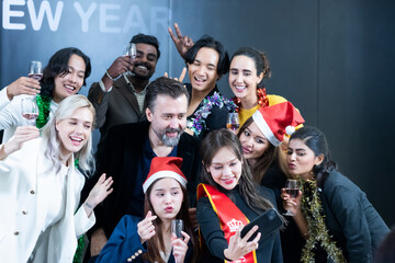 A group of female and male friends of various backgrounds take a selfie during a New Year's party.